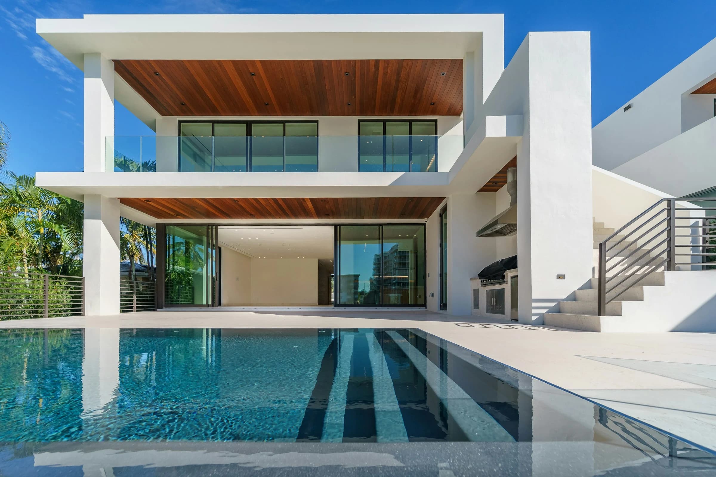 Contemporary luxury villa opening onto a sunlit swimming pool; architectural inspiration, not an available rental.